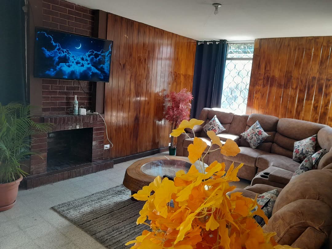 Sala de Heavenly Massage con sillones de gamuza, chimenea de ladrillo, paredes de madera y televisión